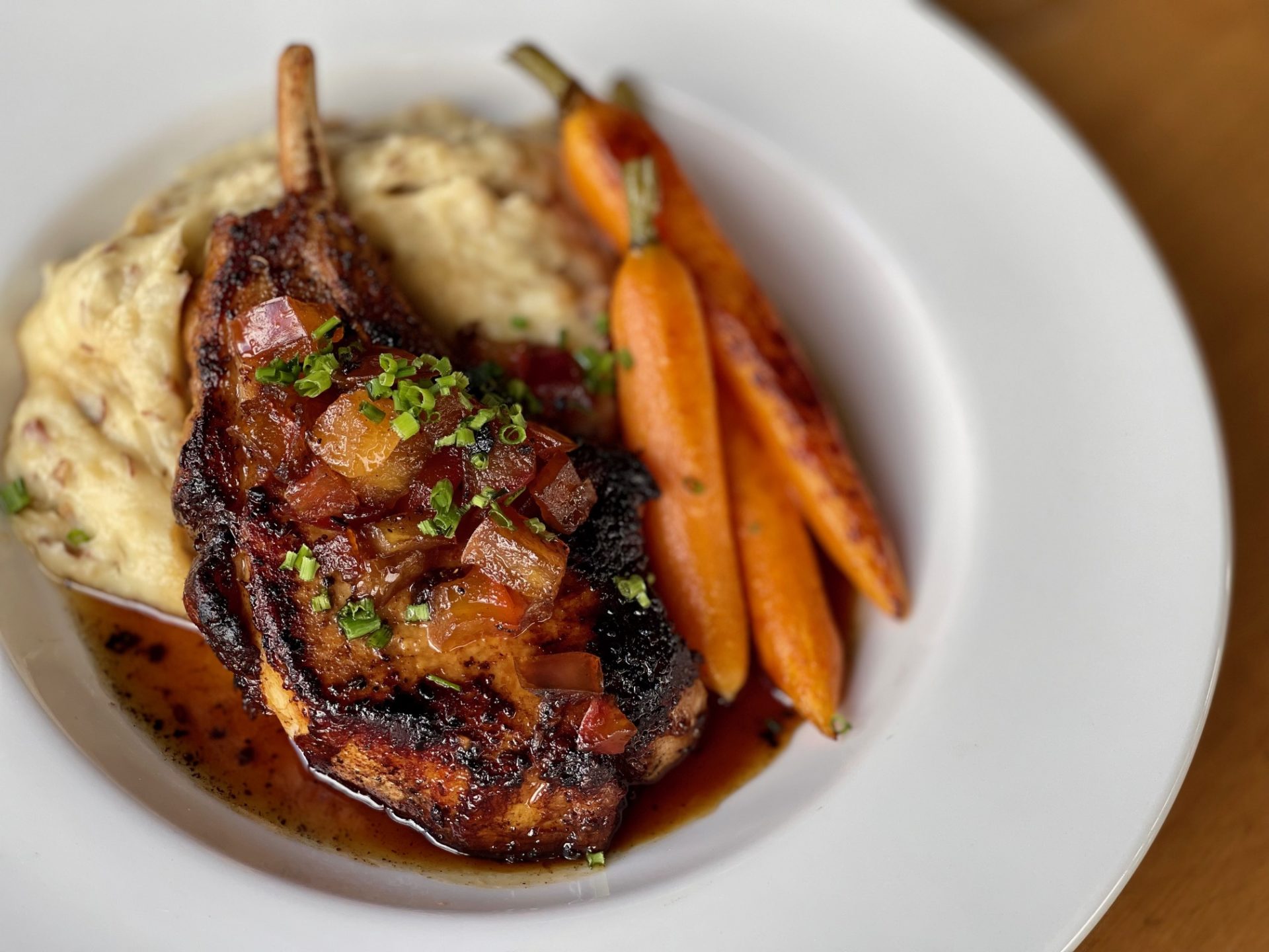 zoomed in picture of porkchop dish with side of carrots and mashed potatoes made by Carte Blanche in Hamburg NY