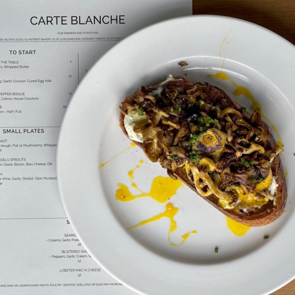 close up of a artisan bread dish with a menu underneath the plate at Carte Blanche Hamburg NY