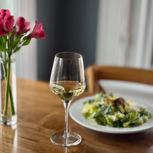 flowers in water and a glass of wine on a table at carte blanche hamburg